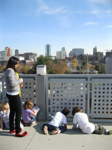 Photo of Katherine Hunt with children overlooking the downtown Knoxville skyline. 